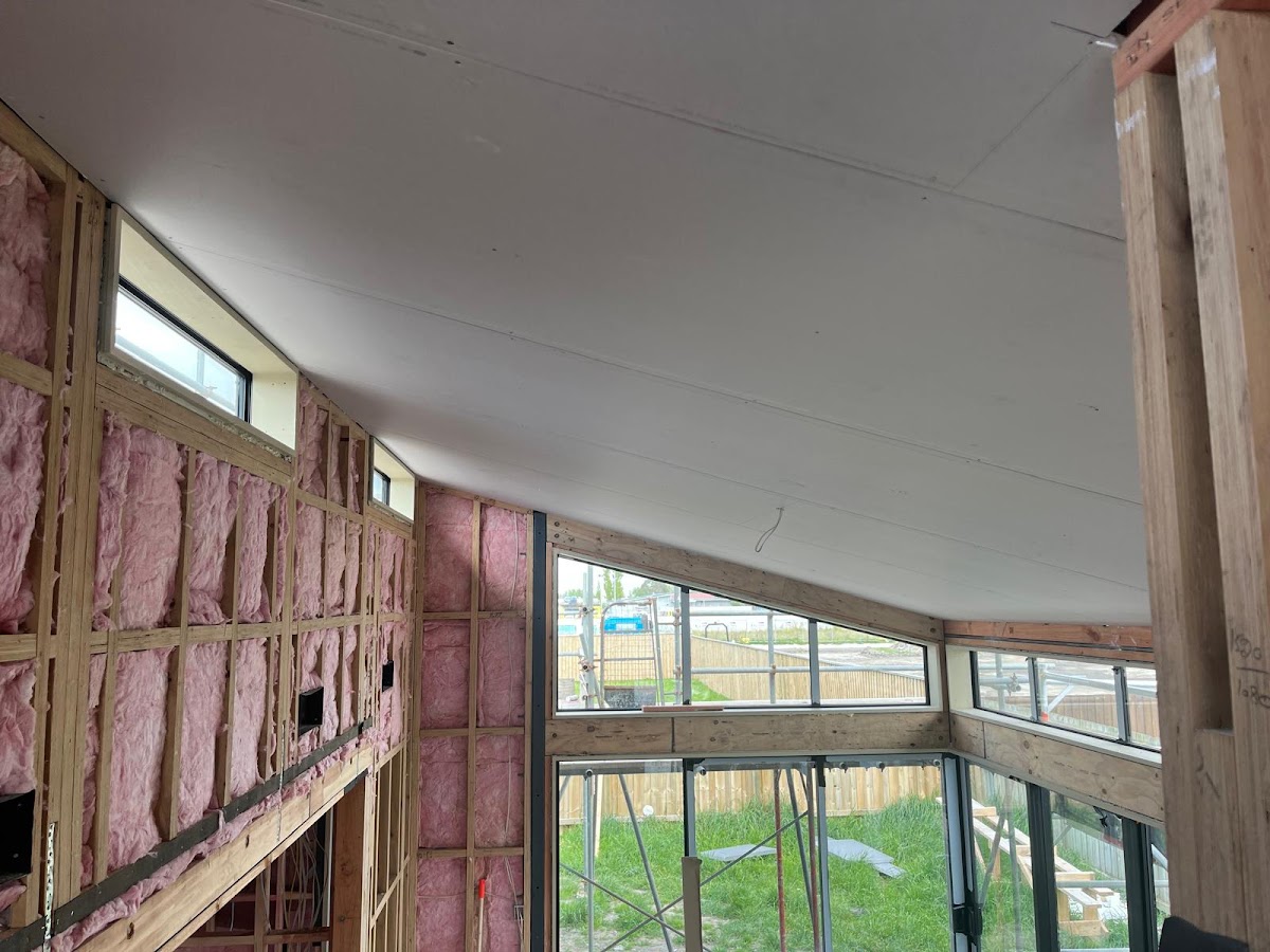 Lined vaulted ceiling above framing and insulation with corner glazing