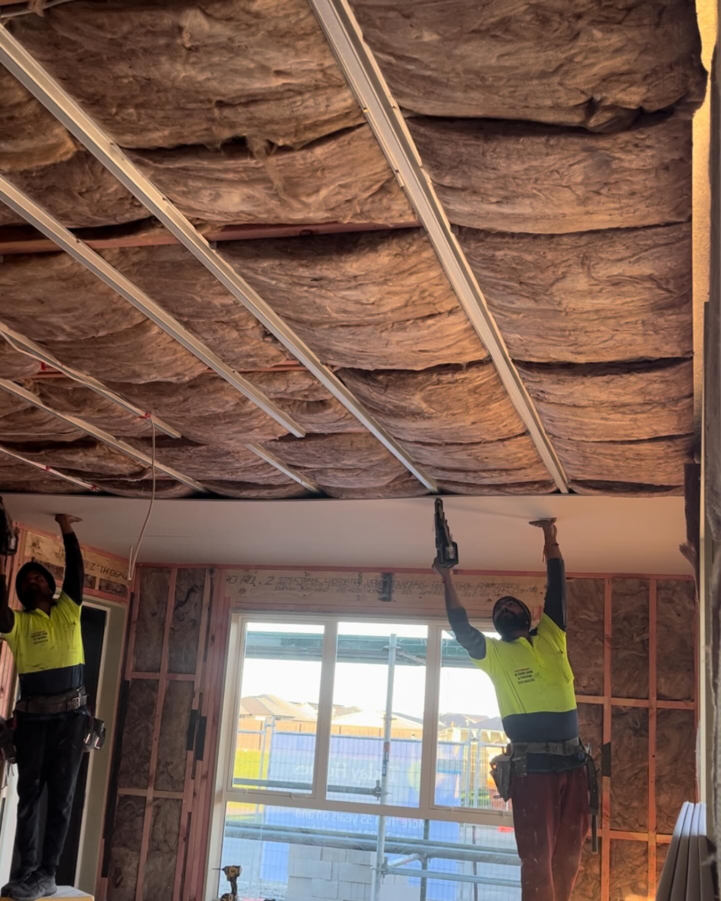 Canterbury Interior Lining crew fixing GIB to a ceiling over fresh insulation